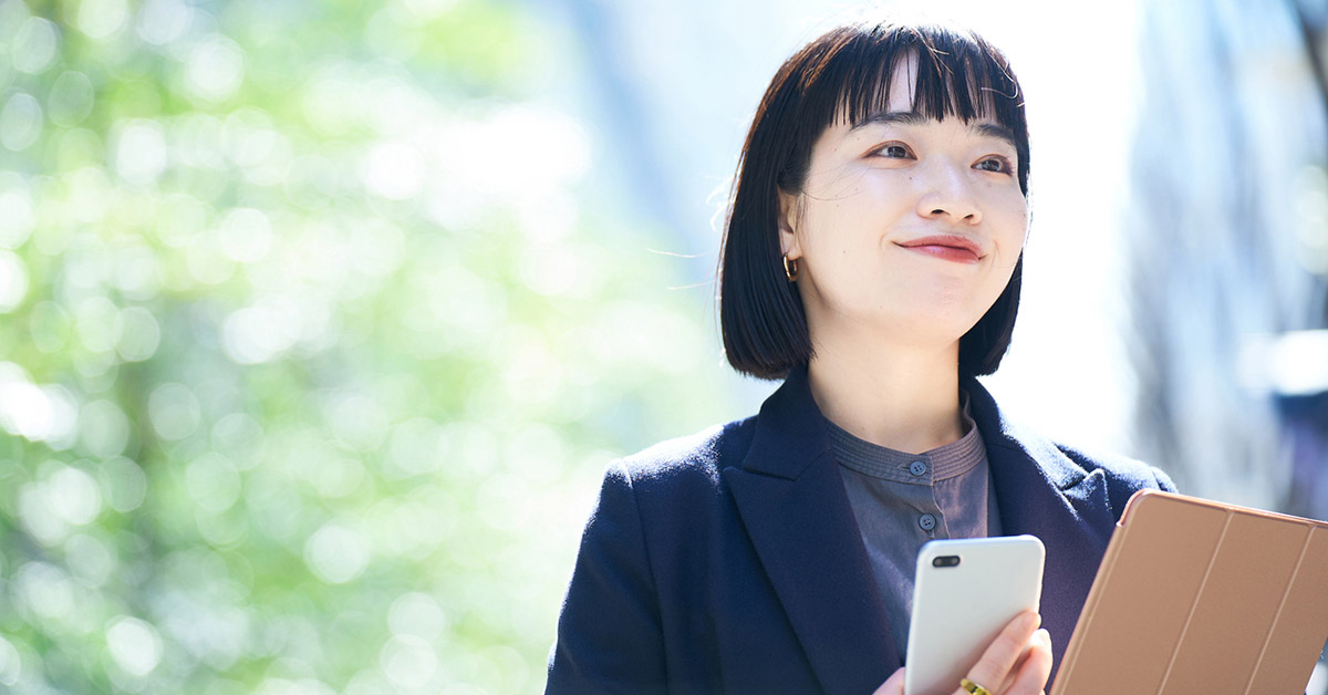 スマートフォンを手に持つ働く女性